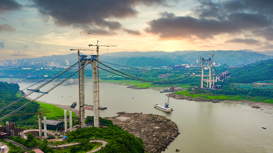 5月25日下午，由中國(guó)鐵建承建的大跨度跨長(zhǎng)江懸索橋——重慶長(zhǎng)壽長(zhǎng)江二橋首段鋼箱梁吊裝成功。圖為航拍下的重慶長(zhǎng)壽長(zhǎng)江二橋施工現(xiàn)場(chǎng)。