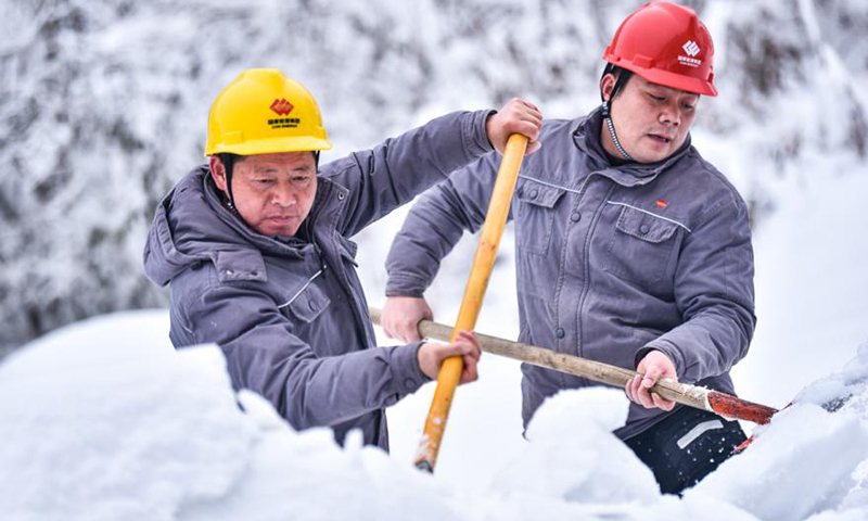 圖為42壩一級水電站兩名員工沿著引水渠道前行，不時將渠道周邊積雪推進(jìn)引水渠道，為二、三、四級水電站爭取更多的水源。大雪期間，這是員工們的“必修課”。