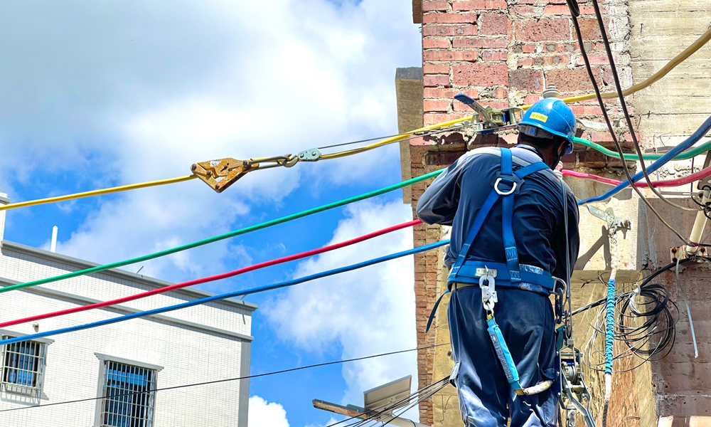 7月22日，南方電網(wǎng)廣東湛江吳川供電局工作人員在給新建臺區(qū)安裝街碼、架設(shè)導線。張國明 攝