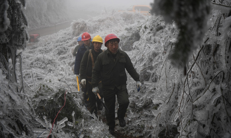 據(jù)了解，自2月8日0時起至2月20日16時，新化縣共有142566戶居民用電受到影響，經(jīng)過181次故障搶修后，目前仍有5017戶用戶送電仍未恢復(fù)。圖為2月20日，在新化縣郭家村，電力工人在冰山中行走。（新華社記者 薛宇舸 攝）