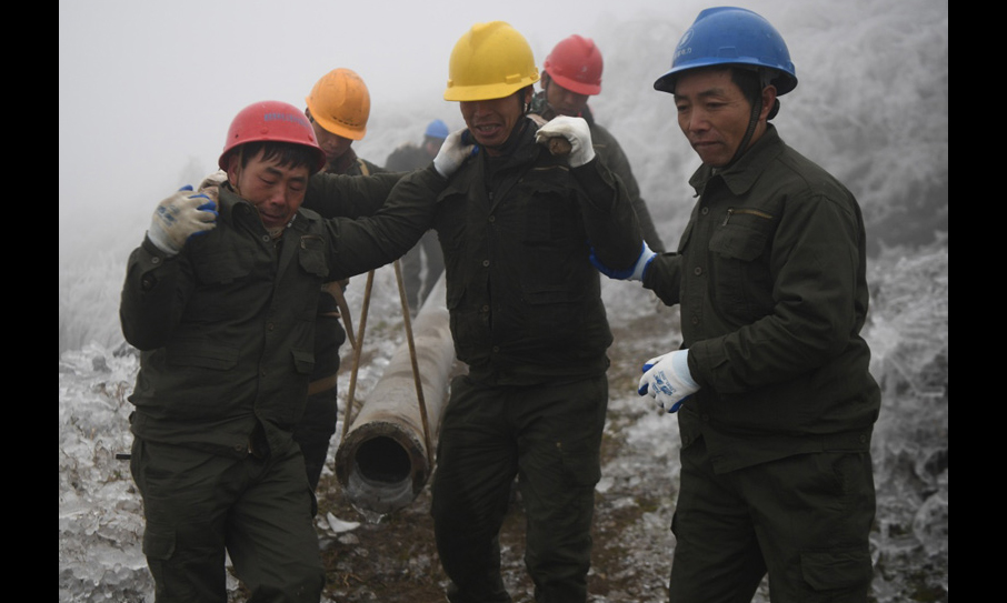 圖為2月20日，在新化縣郭家村，電力工人將電桿抬至倒桿處準備替換。（新華社記者 薛宇舸 攝）