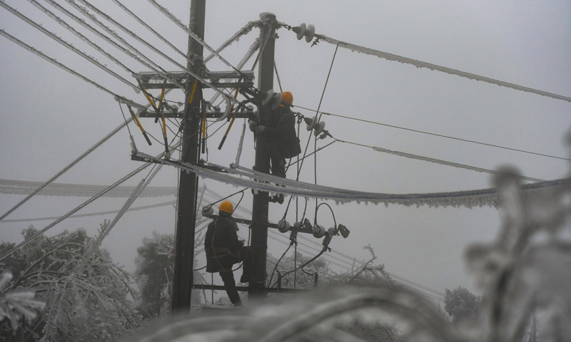 圖為2月20日，電力工人黃通（右）和王放暉在新化縣郭家村進行搶修作業(yè)。（新華社記者 薛宇舸 攝）