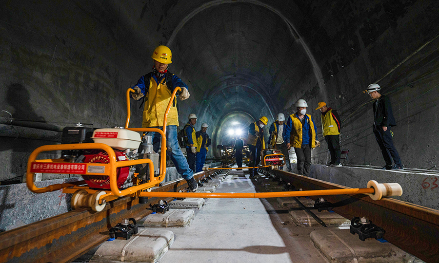 拉林鐵路是西藏首條電氣化鐵路，建成通車后將結(jié)束藏東南地區(qū)沒有鐵路的歷史，改善西藏鐵路網(wǎng)的布局和規(guī)劃，為西藏東部地區(qū)的經(jīng)濟(jì)發(fā)展注入新的活力。目前，項(xiàng)目已完成正線鋪軌126.3公里，其中有砟109.5公里、無砟15.7公里，預(yù)計(jì)今年年底完成全線鋪軌任務(wù)。圖為施工人員正在對(duì)已鋪設(shè)好的軌道安裝扣件。